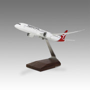A Pacmin Studios desktop model of Qantas Airways Boeing 787-9 aircraft, mounted on a wooden base.